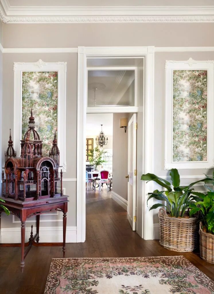 A decorative vintage birdcage beside a hallway.