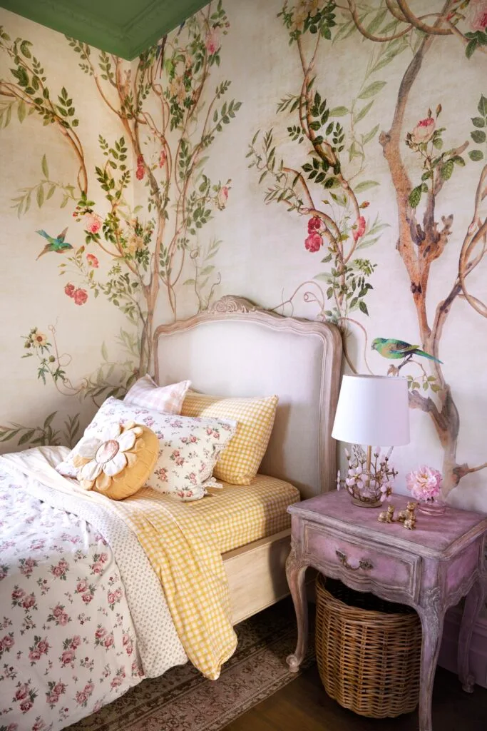 A children's bedroom with tree wallpaper and French style furniture.