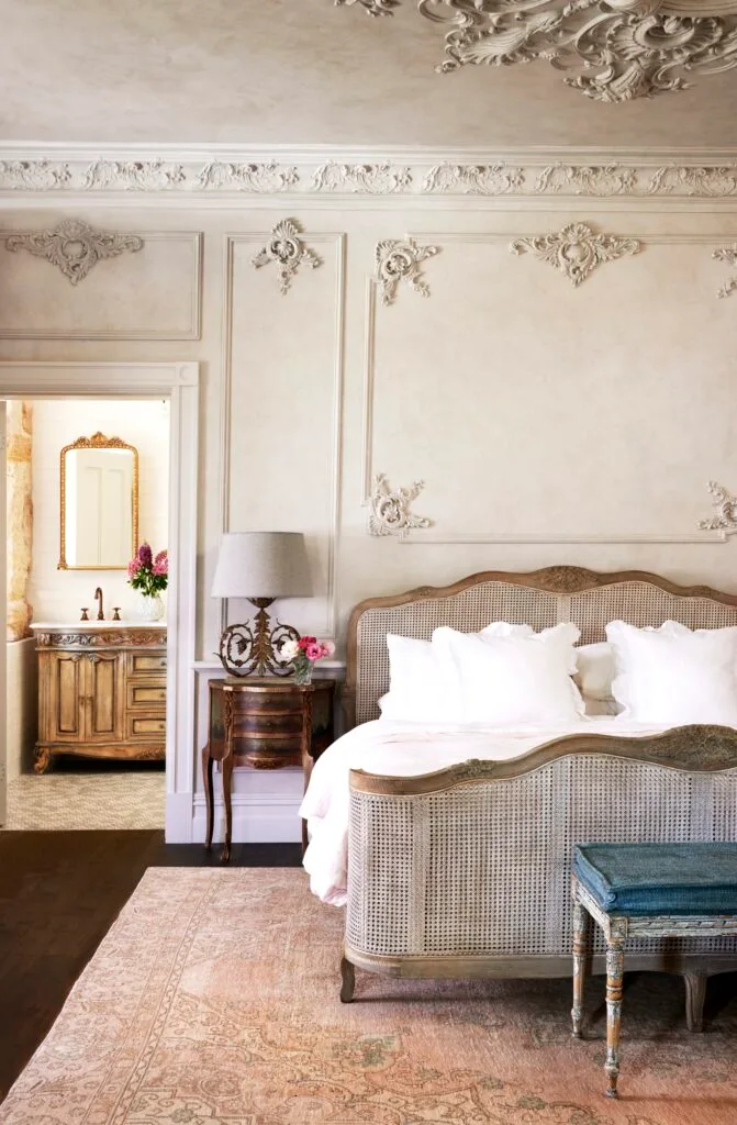 A French provincial style main bedroom with decorative wall mouldings.