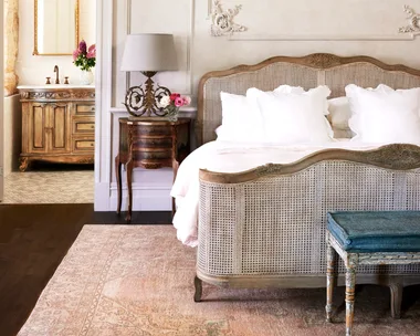 A French provincial style main bedroom with decorative wall mouldings.