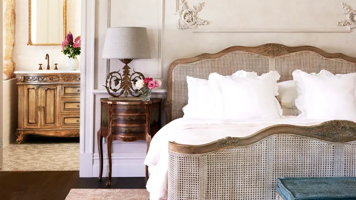 A French provincial style main bedroom with decorative wall mouldings.