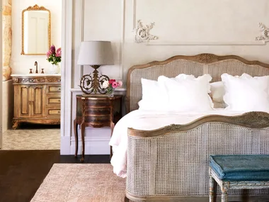 A French provincial style main bedroom with decorative wall mouldings.