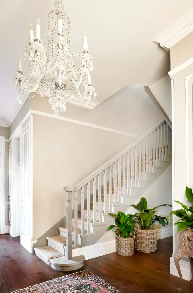 A foyer and staircase with a vintage style chandelier.