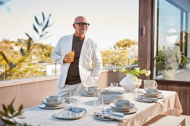 Neale Whitaker stands with decor items and a laid out tablescape