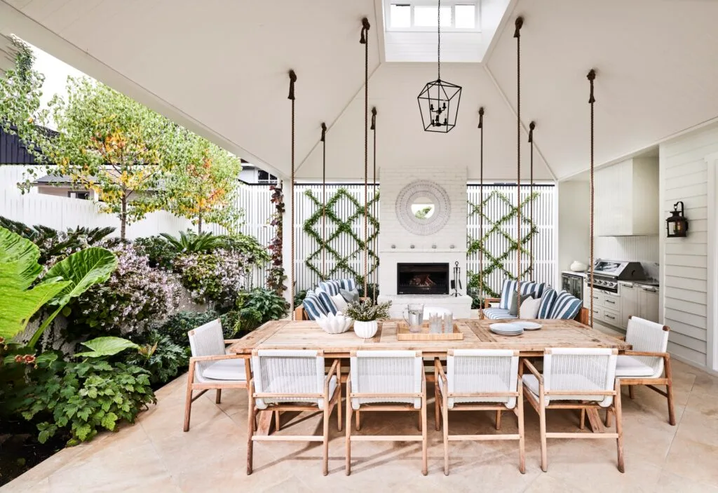 An outdoor alfresco area with a raised roof and timber furniture.