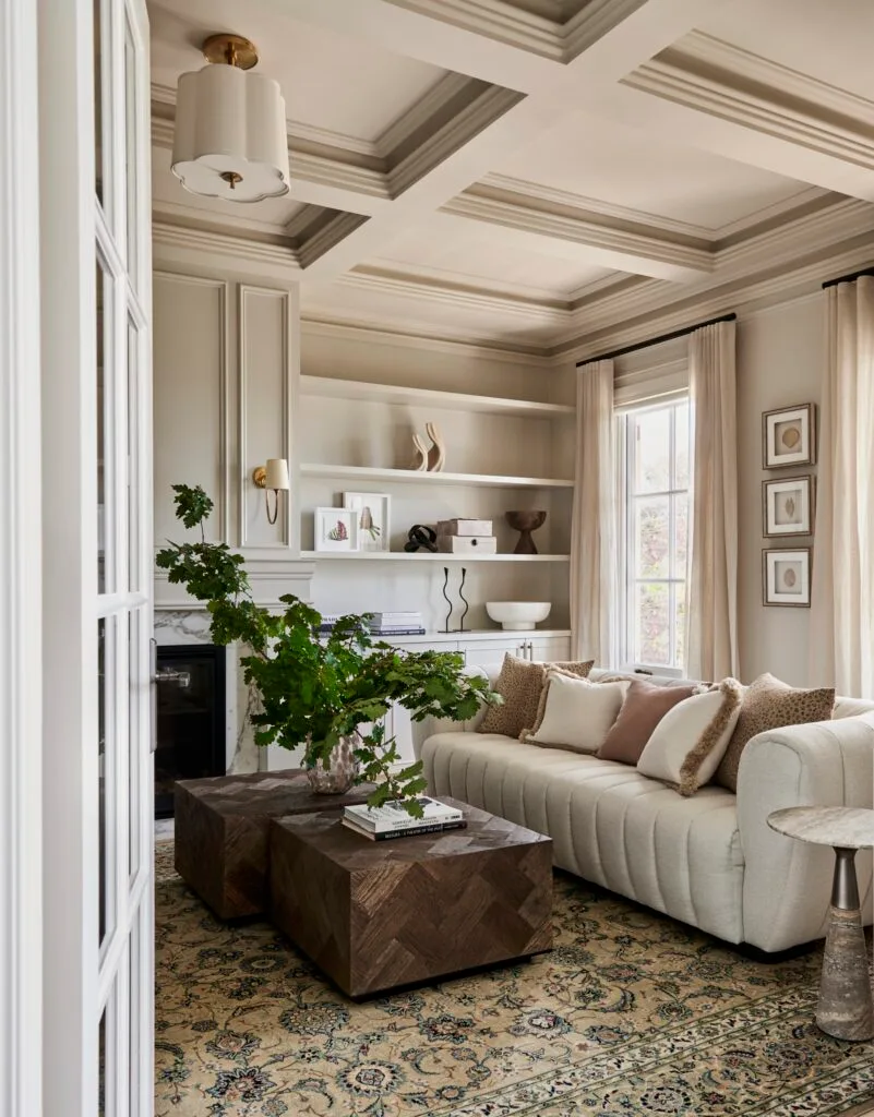 A grand classic-style living room with a timber coffee table and white sofa.