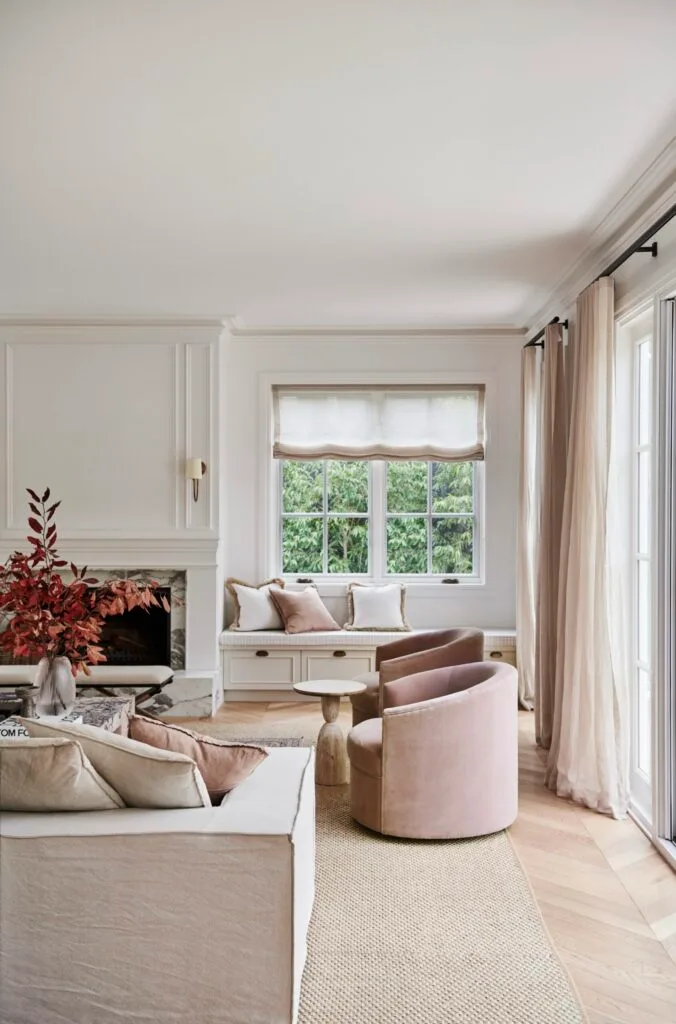 A classic-style living room with a marble fireplace and soft neutral furniture.