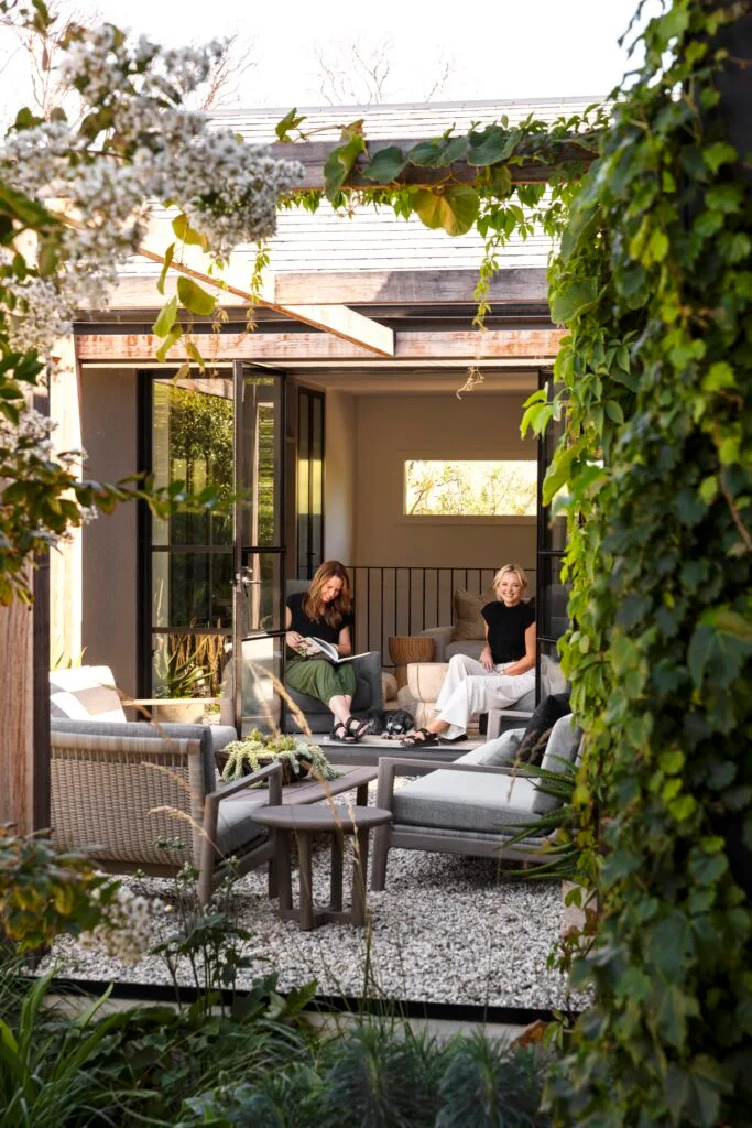 An outdoor alfresco area with an arbour and climbing plants.