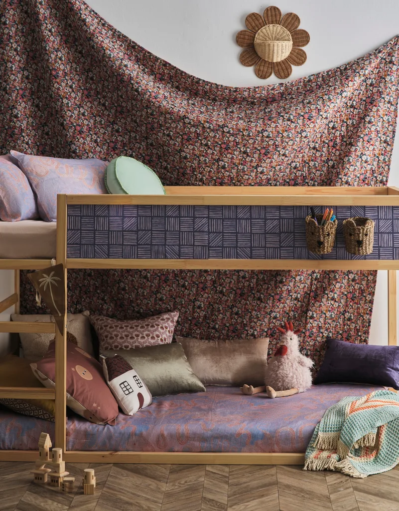 A kid's bunk bed with patterned hanging fabrics.