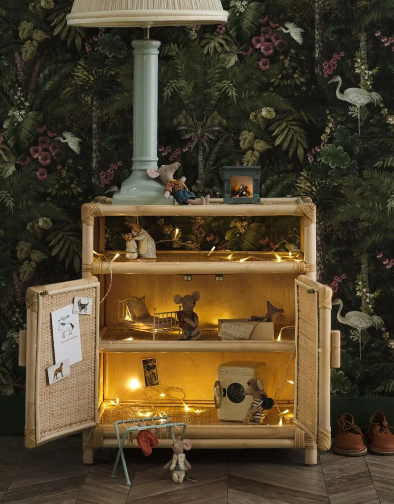 A kid's side table with fairy lights and toy mice.