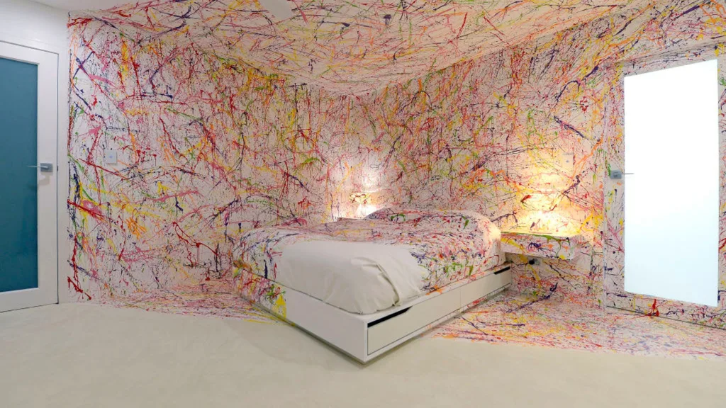 Image of a white room splattered with colourful paint designed by Matt and Kim on The Block. It is often referred to as "the crime scene" bedroom.