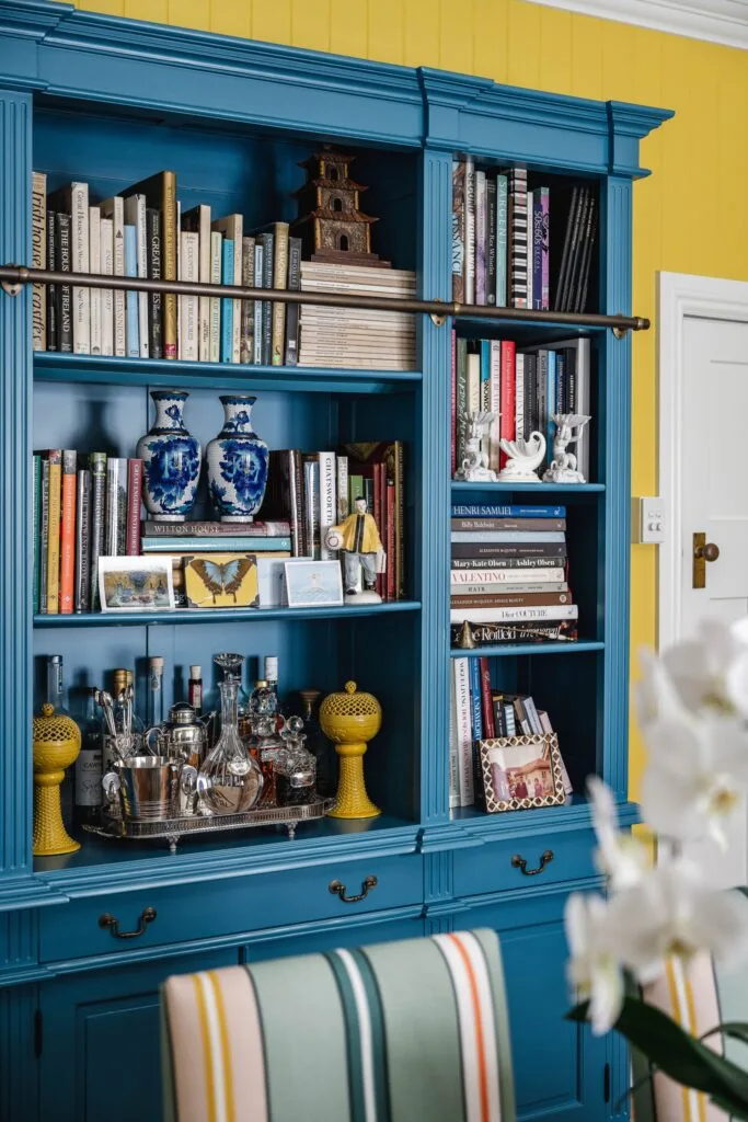 A blue painted cabinet with books and a bar nook.