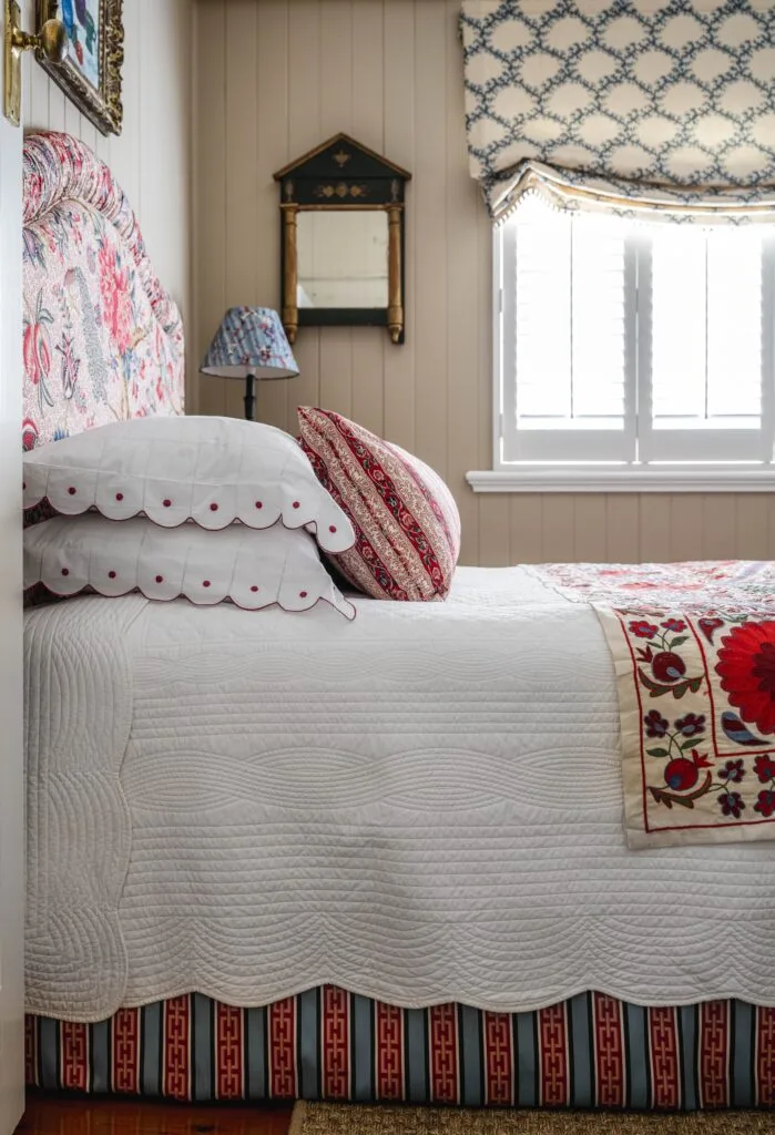 A bed with white and pink floral linens.