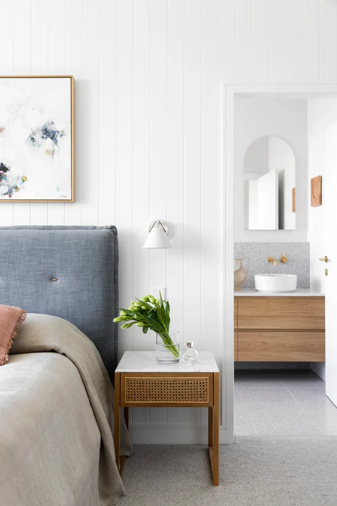 The main bedroom with white wall panels looking into the ensuite.
