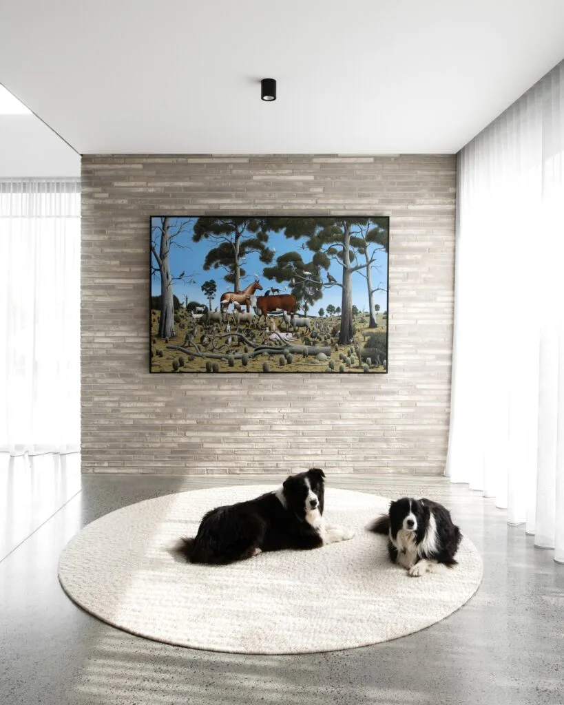 Two border collies sitting on a round white rug in the living room.