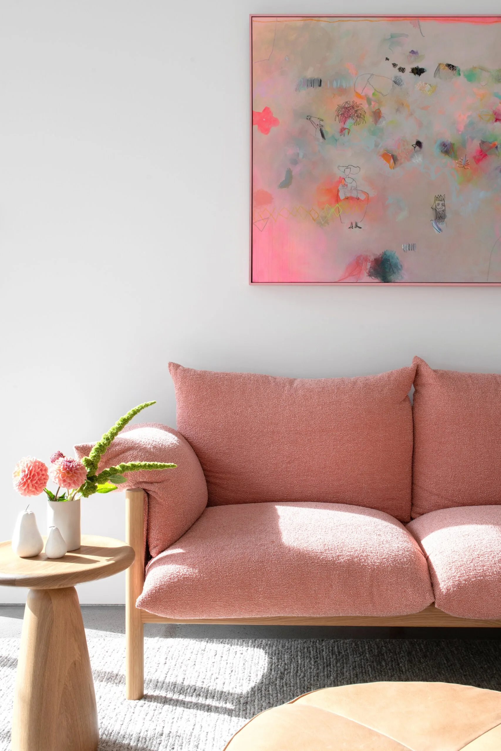 A plush pink couch beneath an abstract artwork in the second living room.