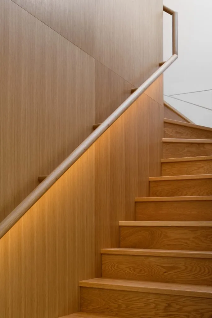 A timber staircase with under-rail lighting.