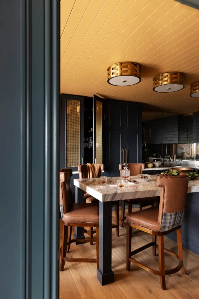 A marble-topped dining table in a yellow and blue kitchen and dining room.