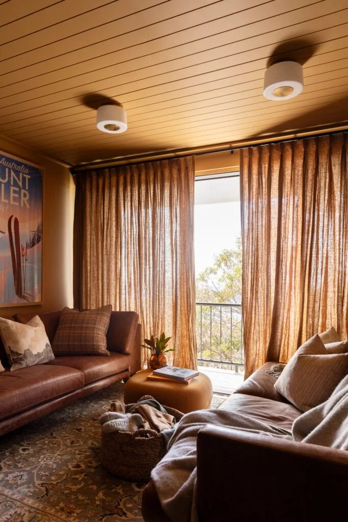 A mustard yellow living area with brown leather sofas.