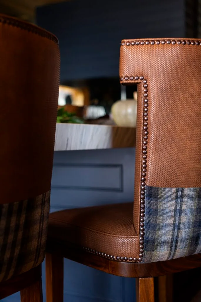 A brown and plaid vinyl bar stool.