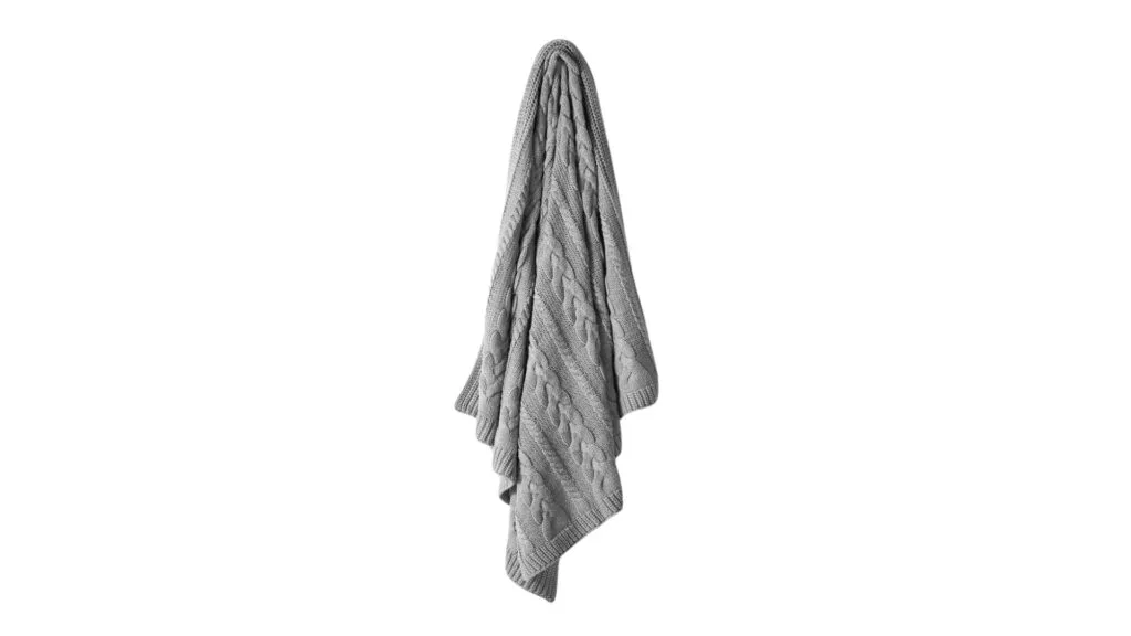 An Aura Home chunky knit blanket throw in Pebble, which is a soft grey.