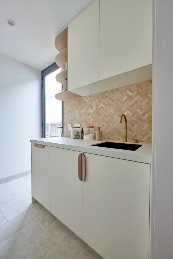 Brad and Mel from Dream Home's laundry is all white with a rustic tiled splashback