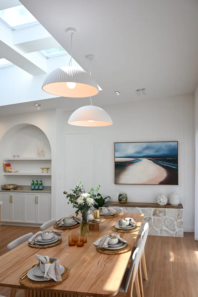 The dining room in Liam's home with a beach scene artwork on the wall.