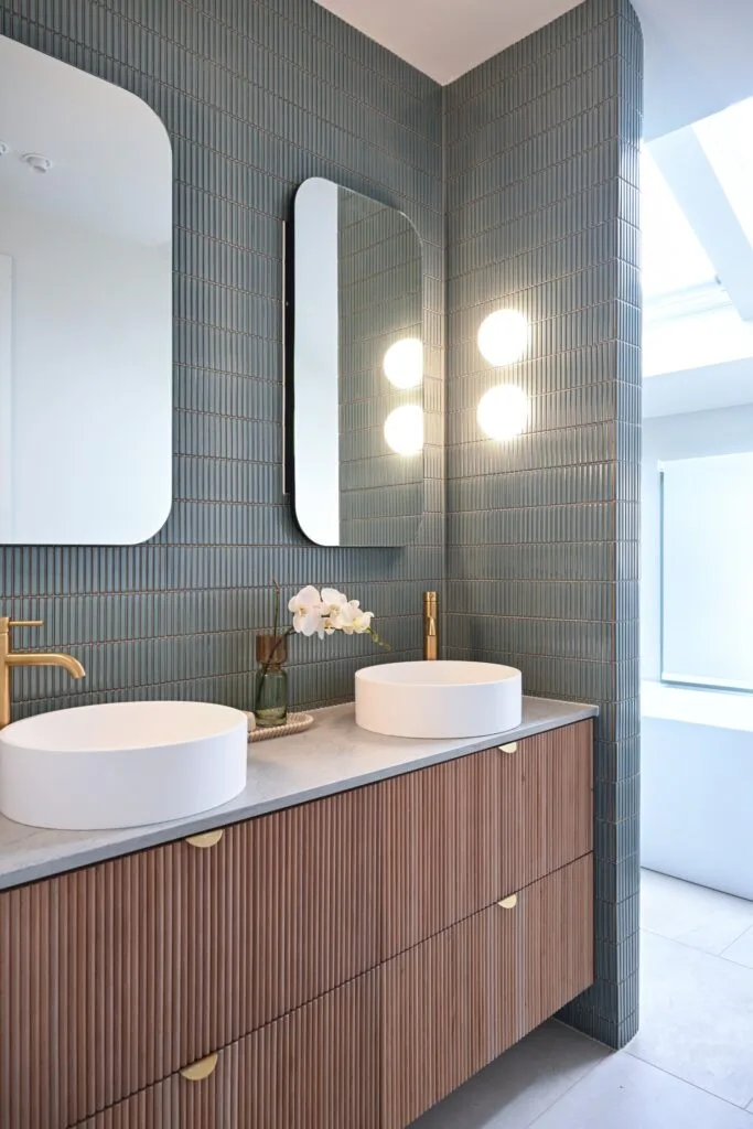 Hannah and Jonny's Dream Home bathroom with walnut coloured vanity cabinetry and teal finger tile walls.