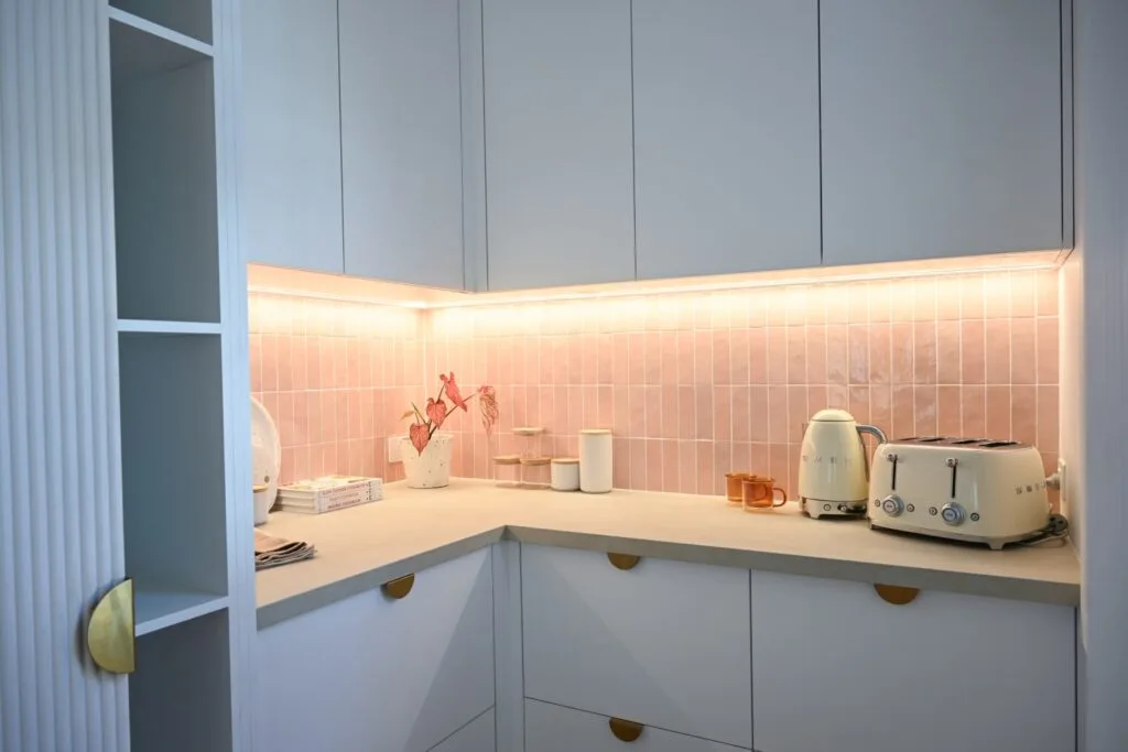 Hannah and Jonny's Dream Home butler's pantry with white cabinets and pink finger tile splashback.