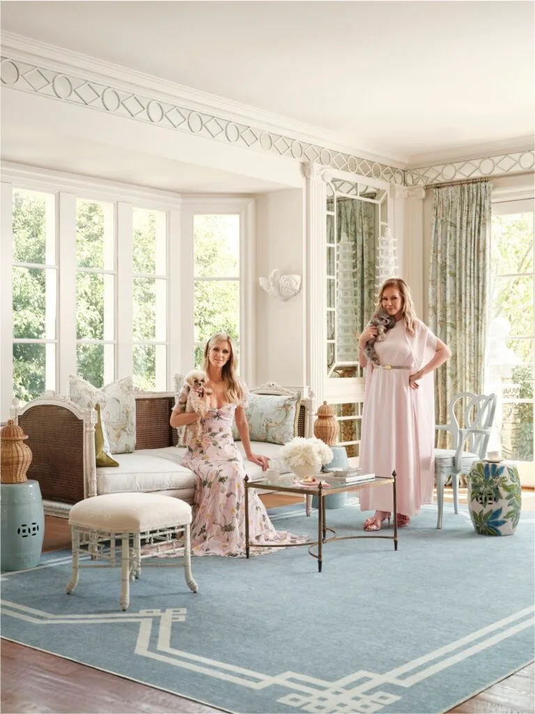 Nicky and Kathy Hilton sit on lounges on a pale blue Ruggable rug from their collection