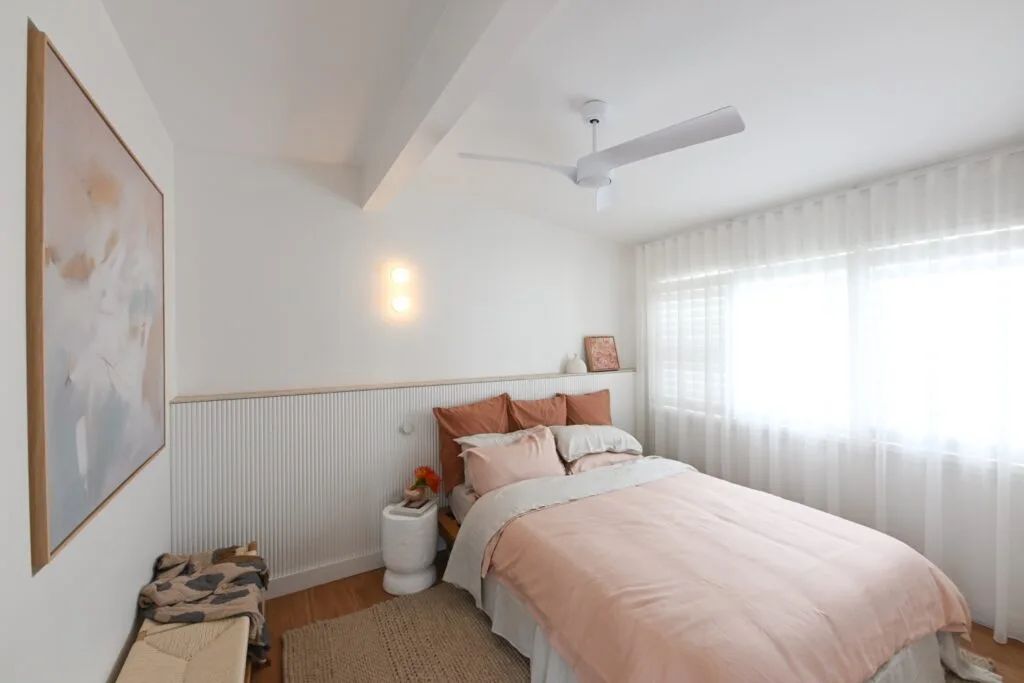 Rhys and Liam's Dream Home guest bedroom with sheer white curtains and terracotta and pale pink bedding.