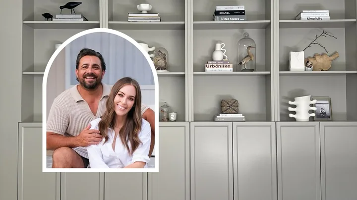 The completed custom-look cabinetry painted in a chic grey with products styled on and The Block couple Ronnie and Georgia smiling inset.