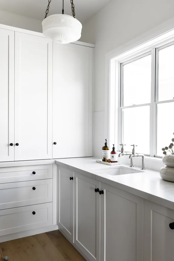 An all-white butler's pantry with shaker style cabinets.