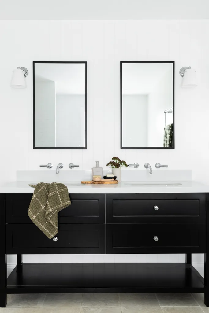 An ensuite with a double basin black and white vanity.