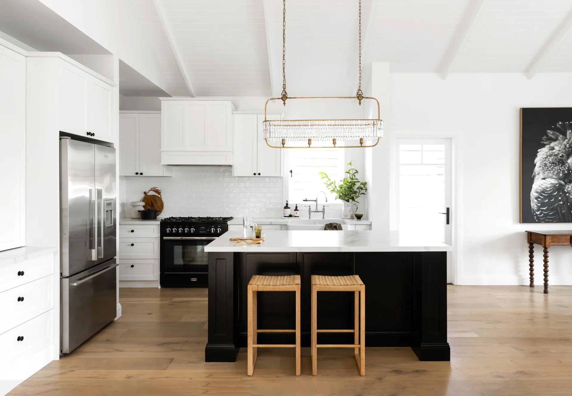 A white and black Hamptons style kitchen with raised ceilings.