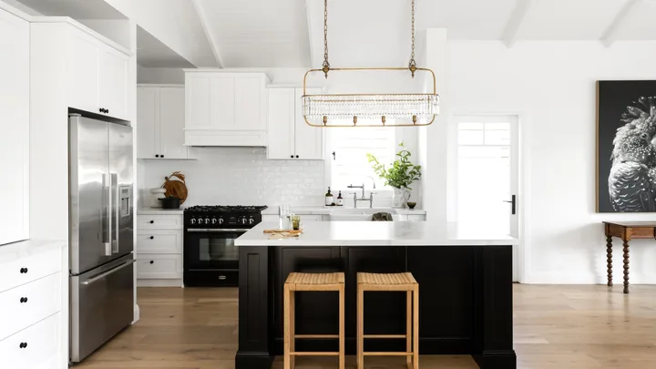 A white and black Hamptons style kitchen with raised ceilings.