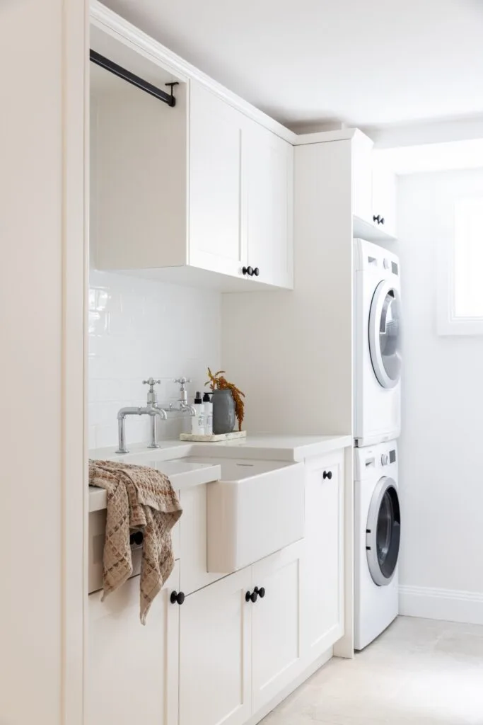 A white Hamptons style laundry with a farmhouse sink.