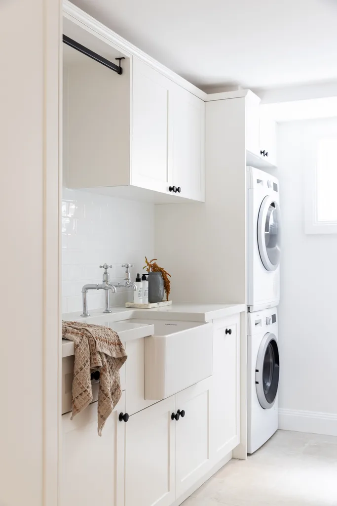 A white Hamptons style laundry with a farmhouse sink.