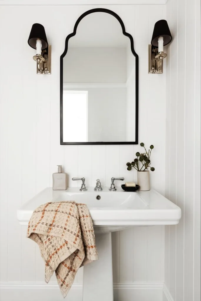 A Hamptons style powder room with VJ panels and pedestal basin.