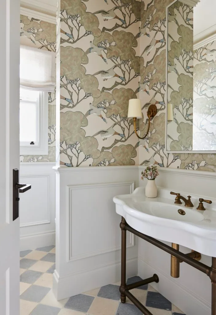 A classic style powder room with a pedestal basin and flying ducks wallpaper.