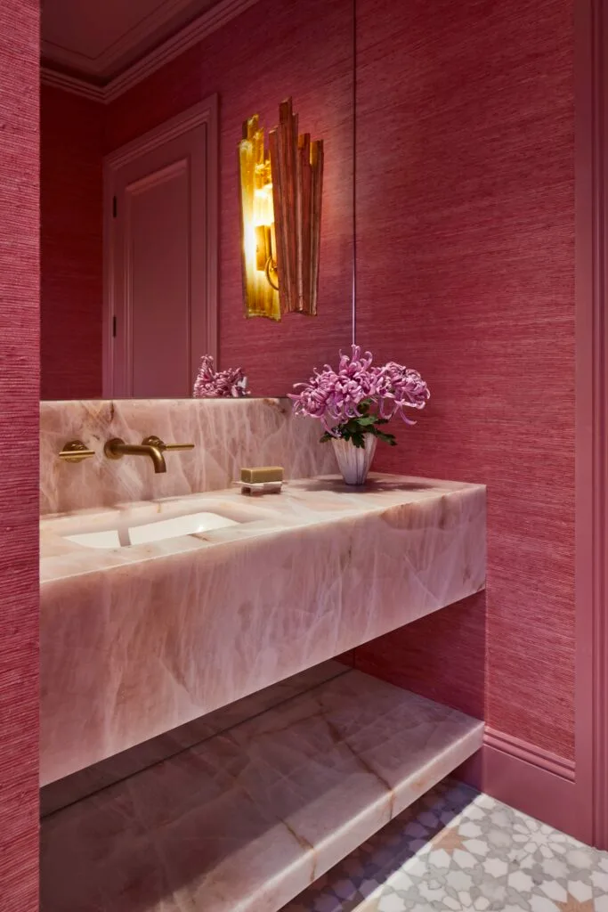 A pink powder room with a quartzite slab vanity.