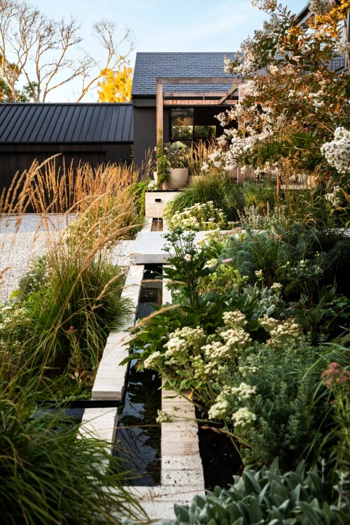 A linear water feature beside limestone steppers.