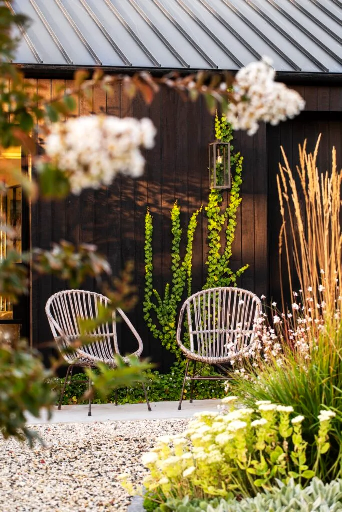 Two outdoor chairs surrounded by seasonal blooms.