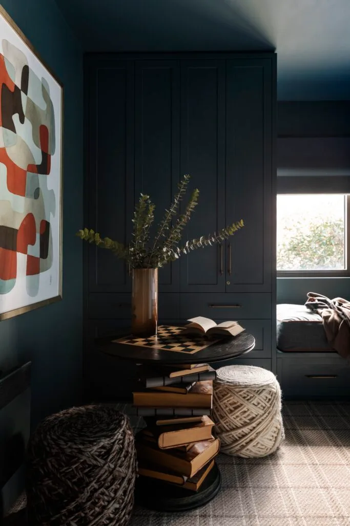 A dark nook with a games table and woven stools.