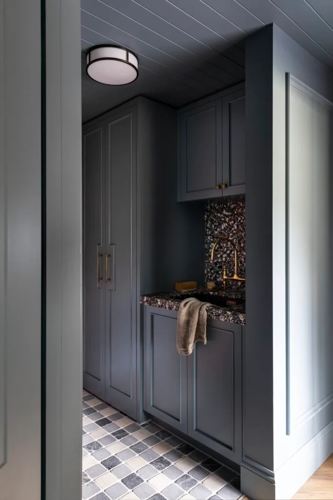 A laundry in teal with a checked tile floor and vj panelling.