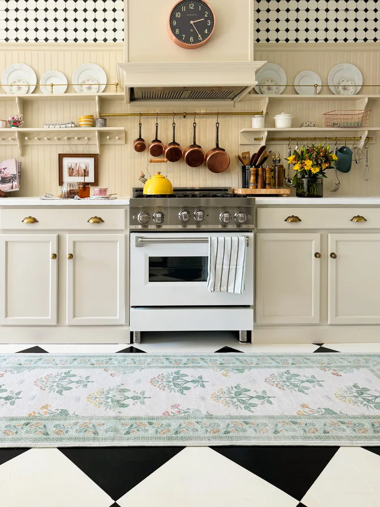 Butter yellow kitchen cabinetry with a floral rug runner.