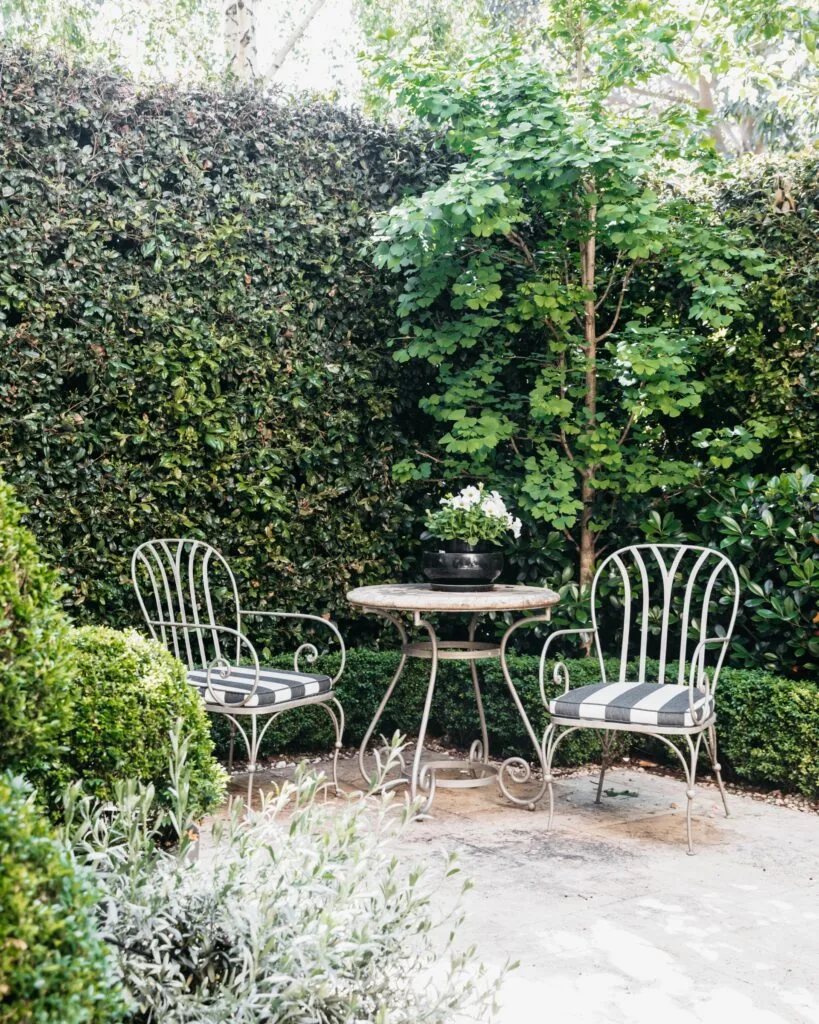 An alfresco area nook with two metal seats and a table.