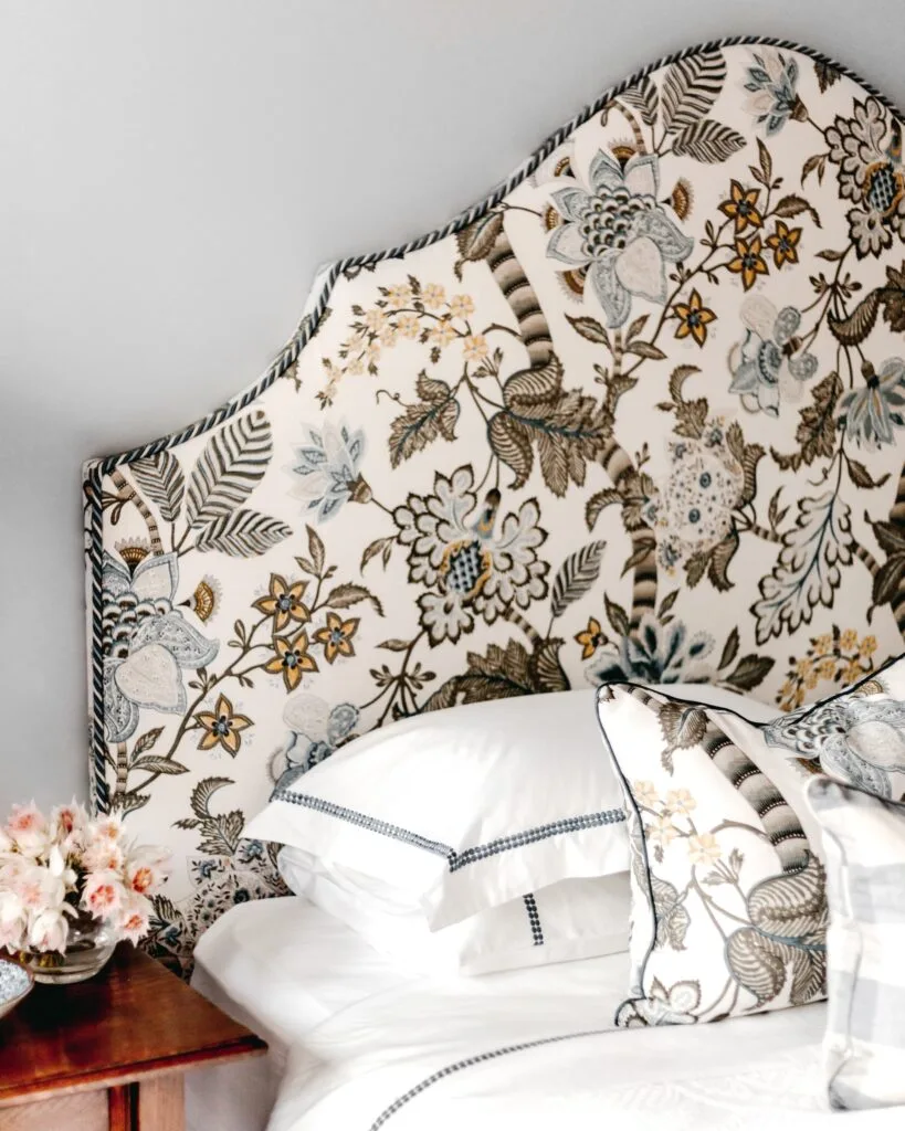 A vintage-style bedhead with a subdued floral fabric.