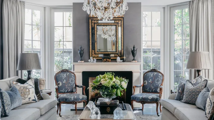 A classic sitting room with a glass chandelier and vintage-style furniture.