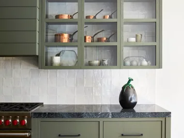 A modern farmhouse style kitchen with greige cabinetry and drawers.